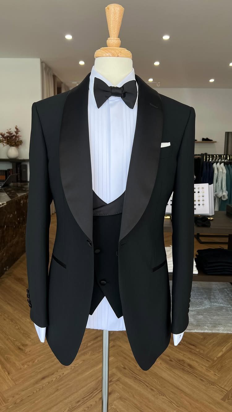 Black tuxedo jacket with shawl lapels and bow tie on a white mannequin.