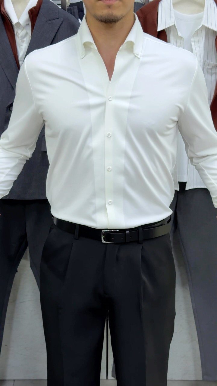 Man wearing a white button-down shirt, black trousers, and a black leather belt.