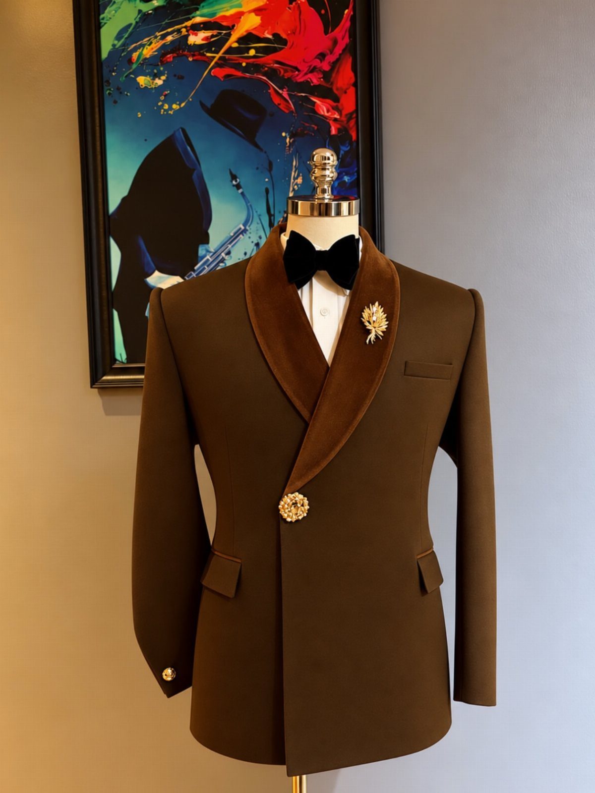 Brown formal suit jacket with velvet shawl collar and gold brooches on a mannequin.