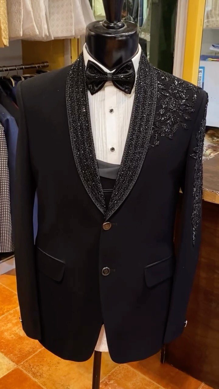 Black tuxedo jacket with beaded shawl lapel and bow tie on a mannequin.