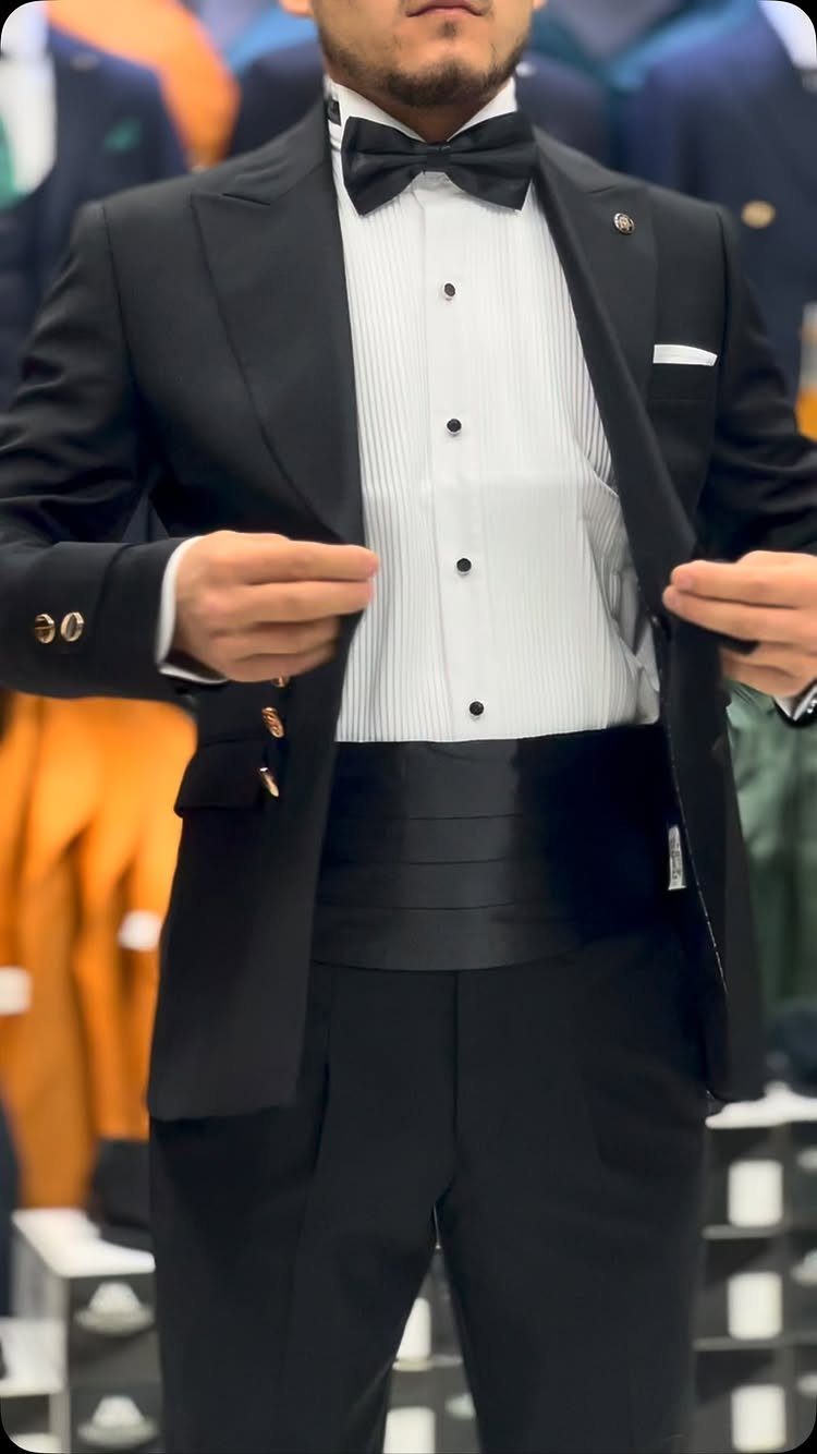 Man in a black tuxedo with a white pleated shirt and black bow tie.