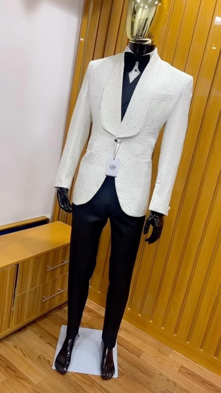 Mannequin wearing a white textured tuxedo jacket with black trousers and a bow tie.