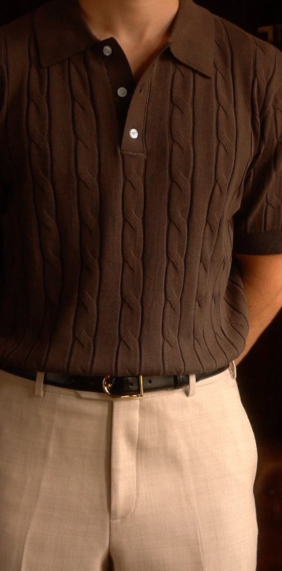 Man wearing a brown cable-knit polo shirt and beige trousers with a black belt.