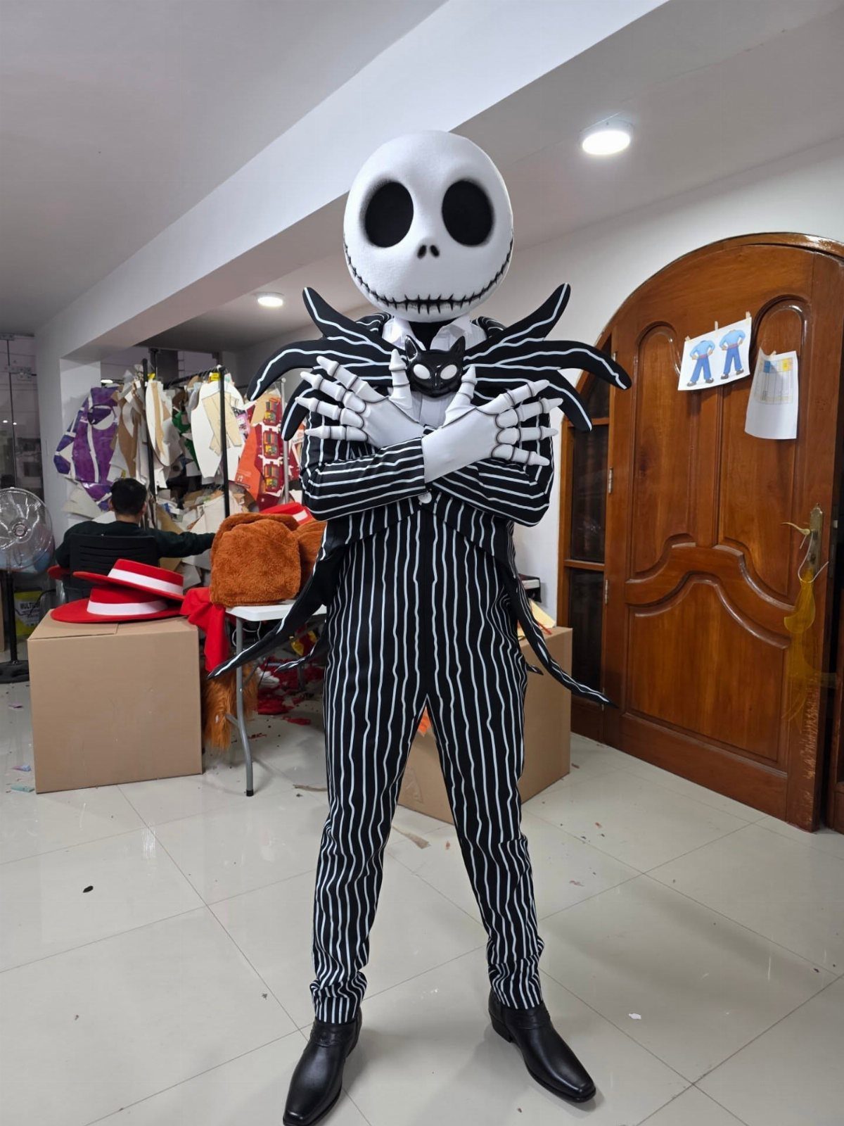 Person in a Jack Skellington pinstripe suit and skull mask posing with crossed arms.