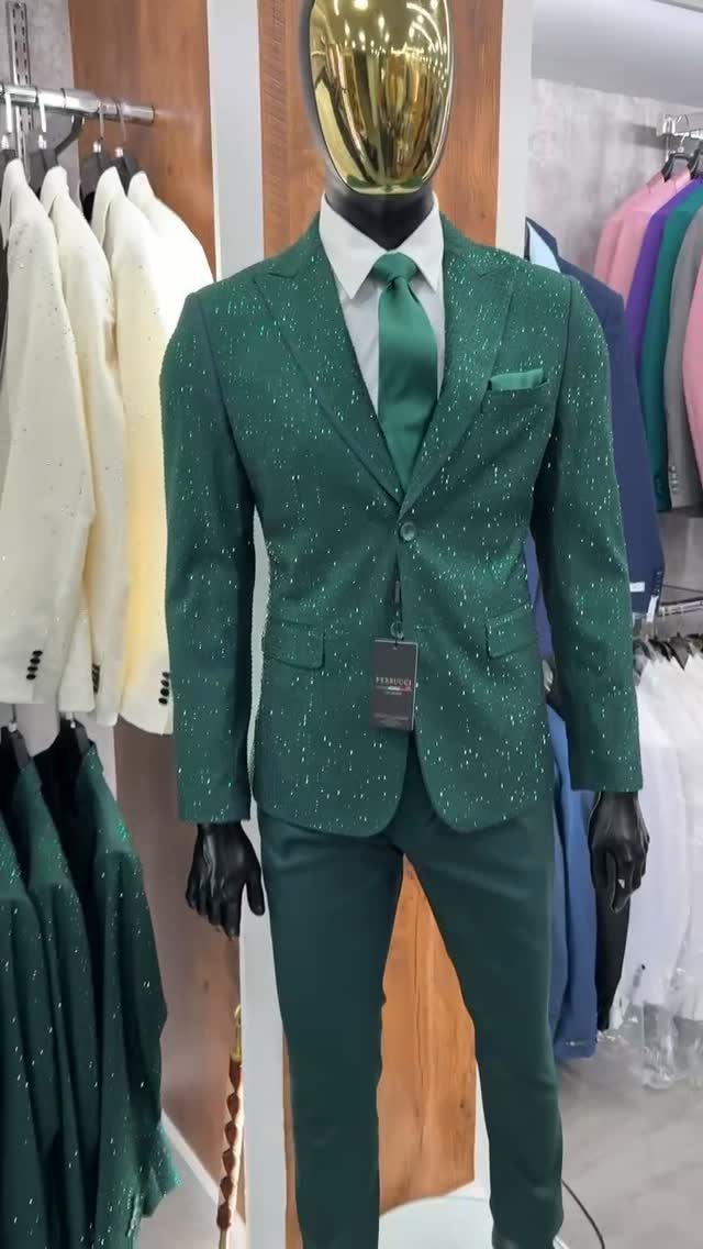 Mannequin wearing a sparkling emerald green suit with a matching tie and white shirt.