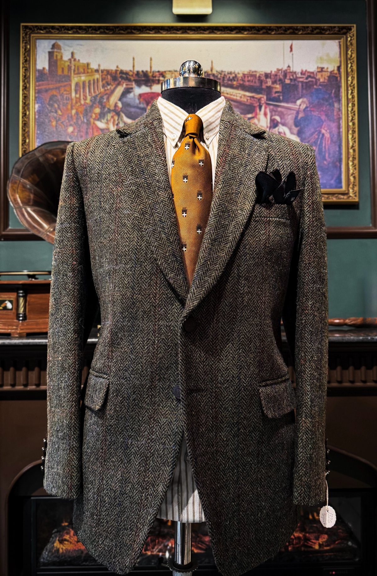 Brown tweed blazer on a mannequin with a striped shirt and patterned yellow tie.