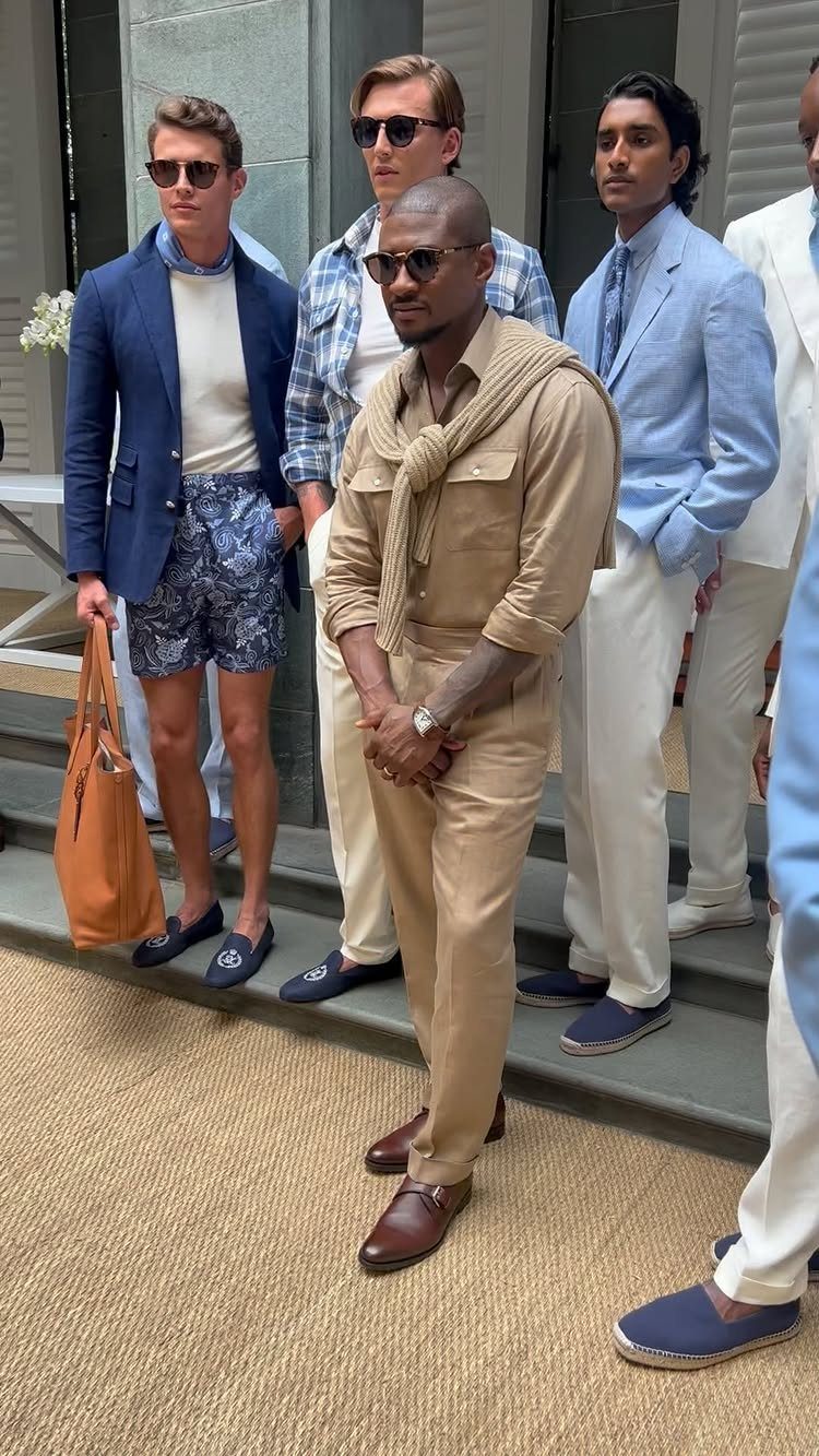 Four men posing in stylish preppy clothing including blazers, chinos, and loafers.