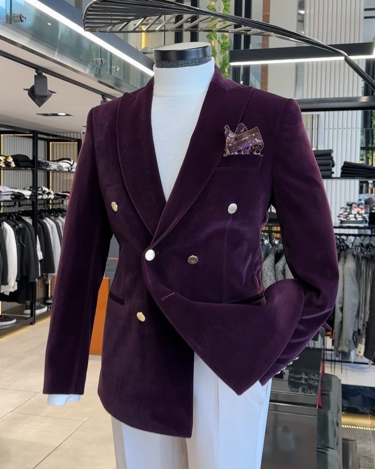 Deep purple velvet double-breasted blazer with gold buttons on a white mannequin.