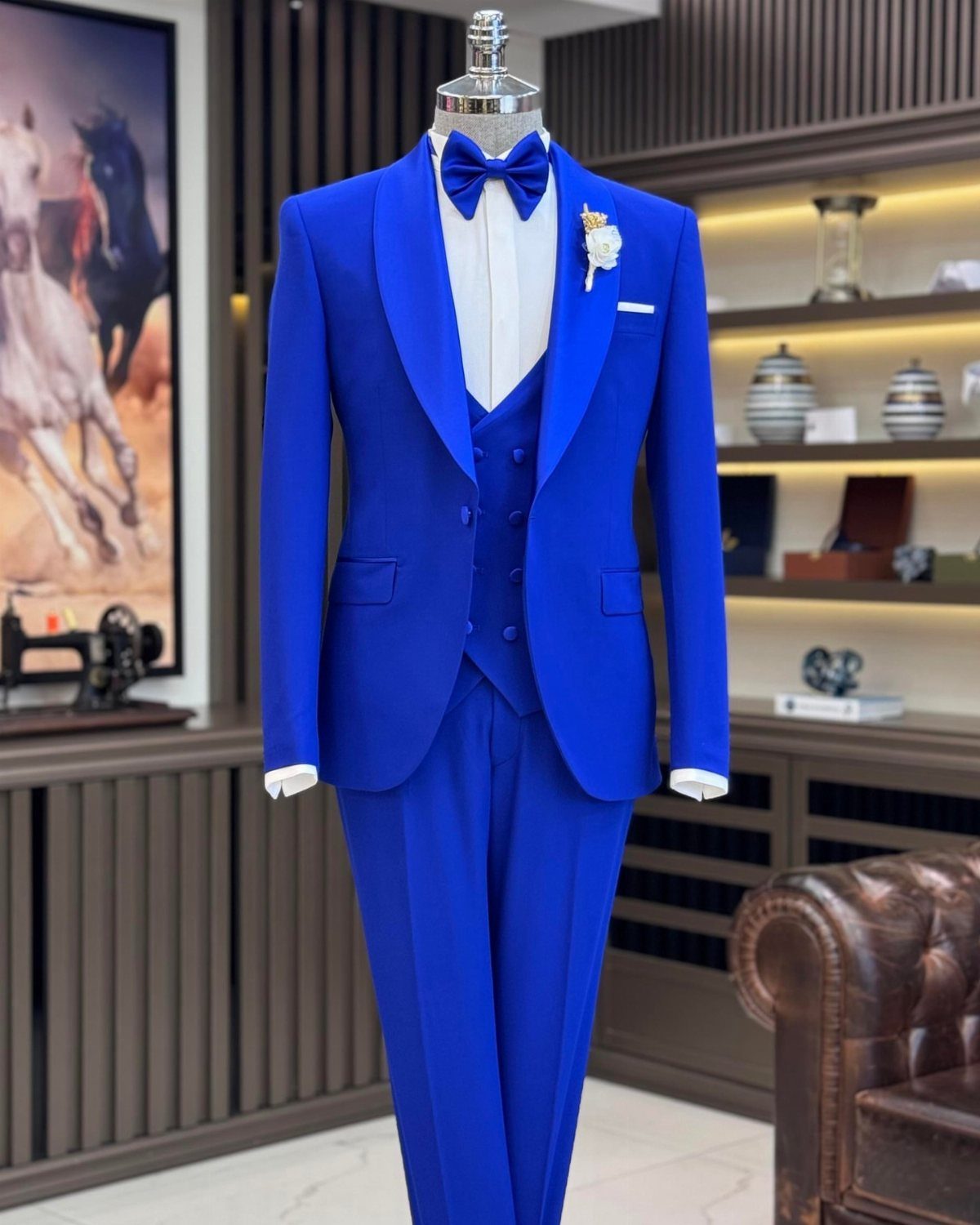 Bright blue three-piece tuxedo with black shawl lapels on a mannequin.