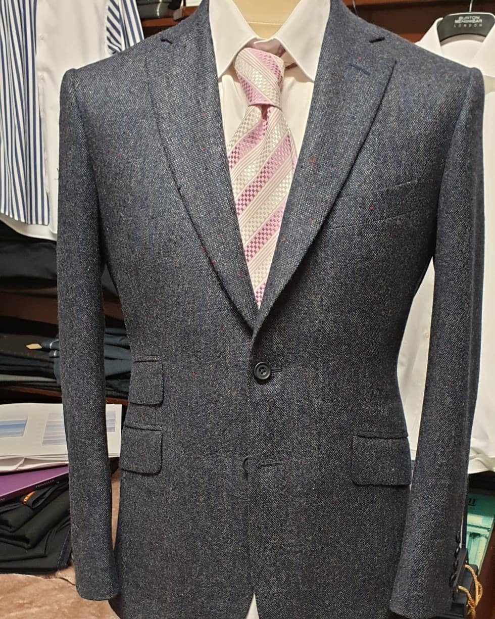 Charcoal grey tweed slim-fit blazer worn with a white shirt and pink striped tie.
