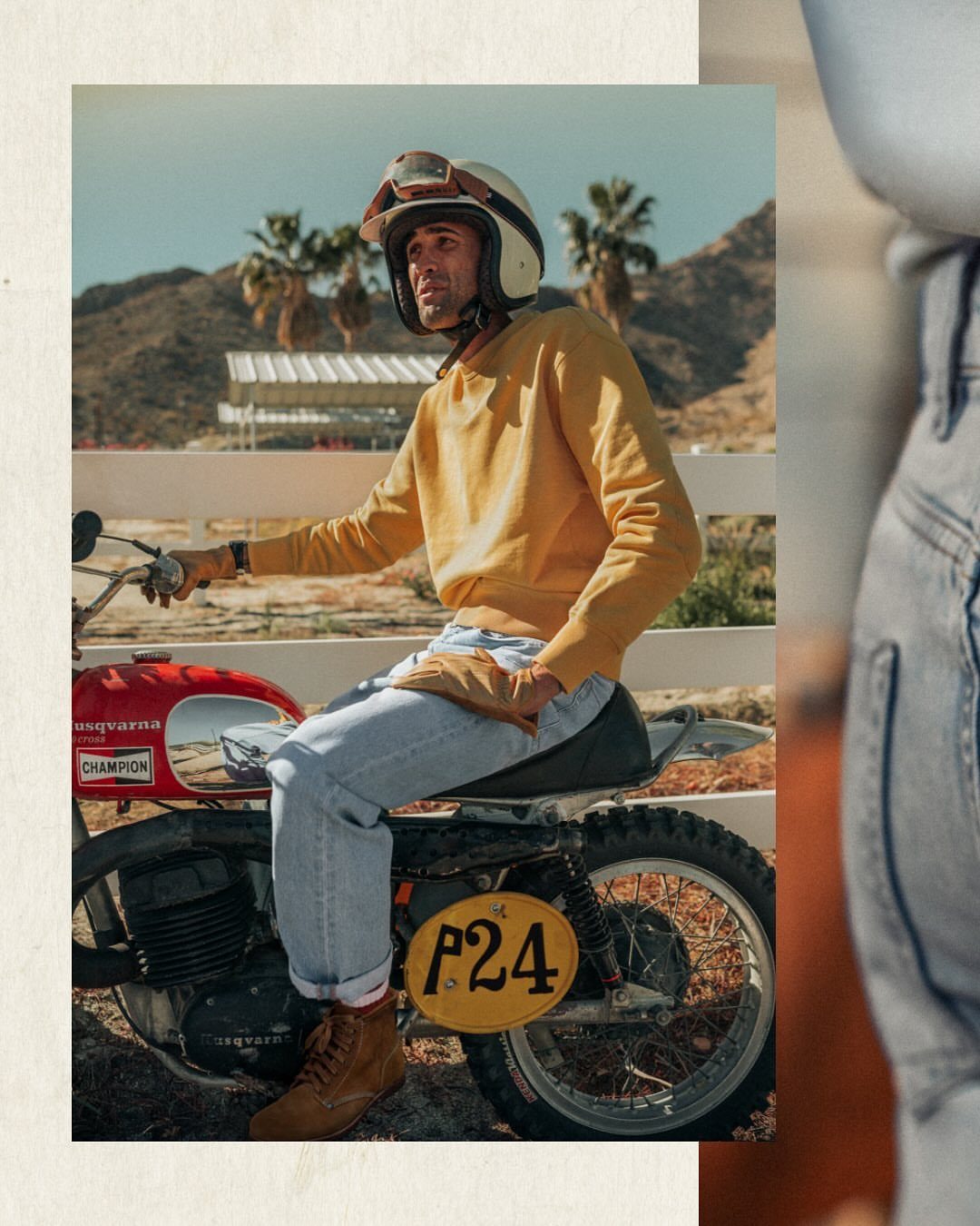 Man in yellow sweatshirt and jeans sitting on a vintage red Husqvarna motorcycle in a desert setting.