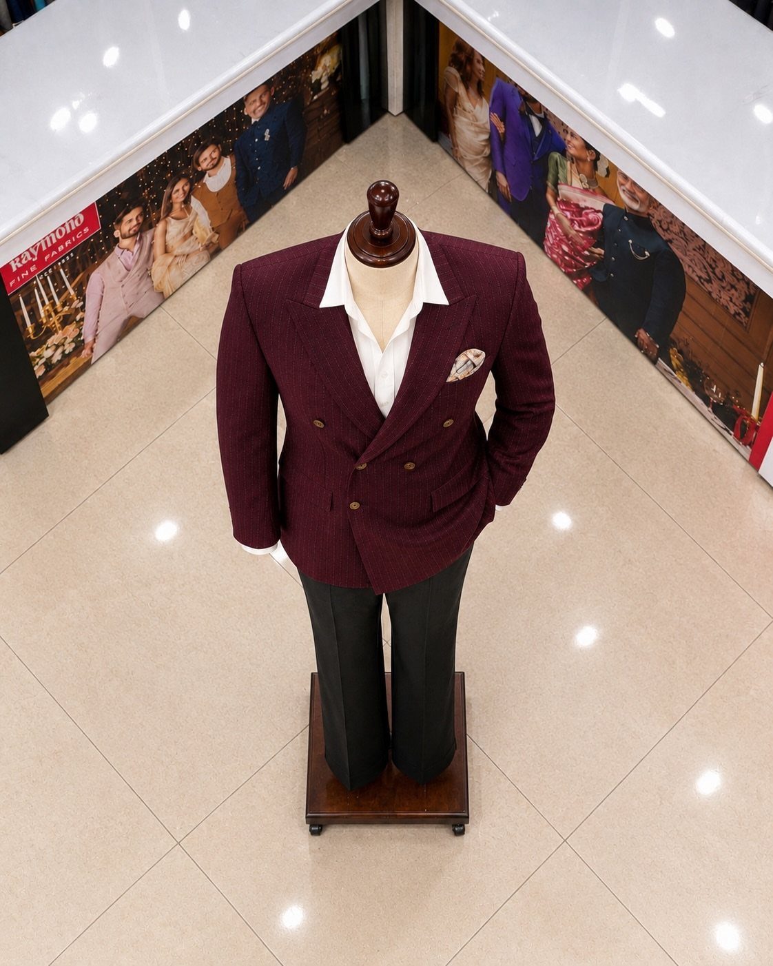 A maroon double-breasted suit jacket and white shirt displayed on a mannequin with black trousers.