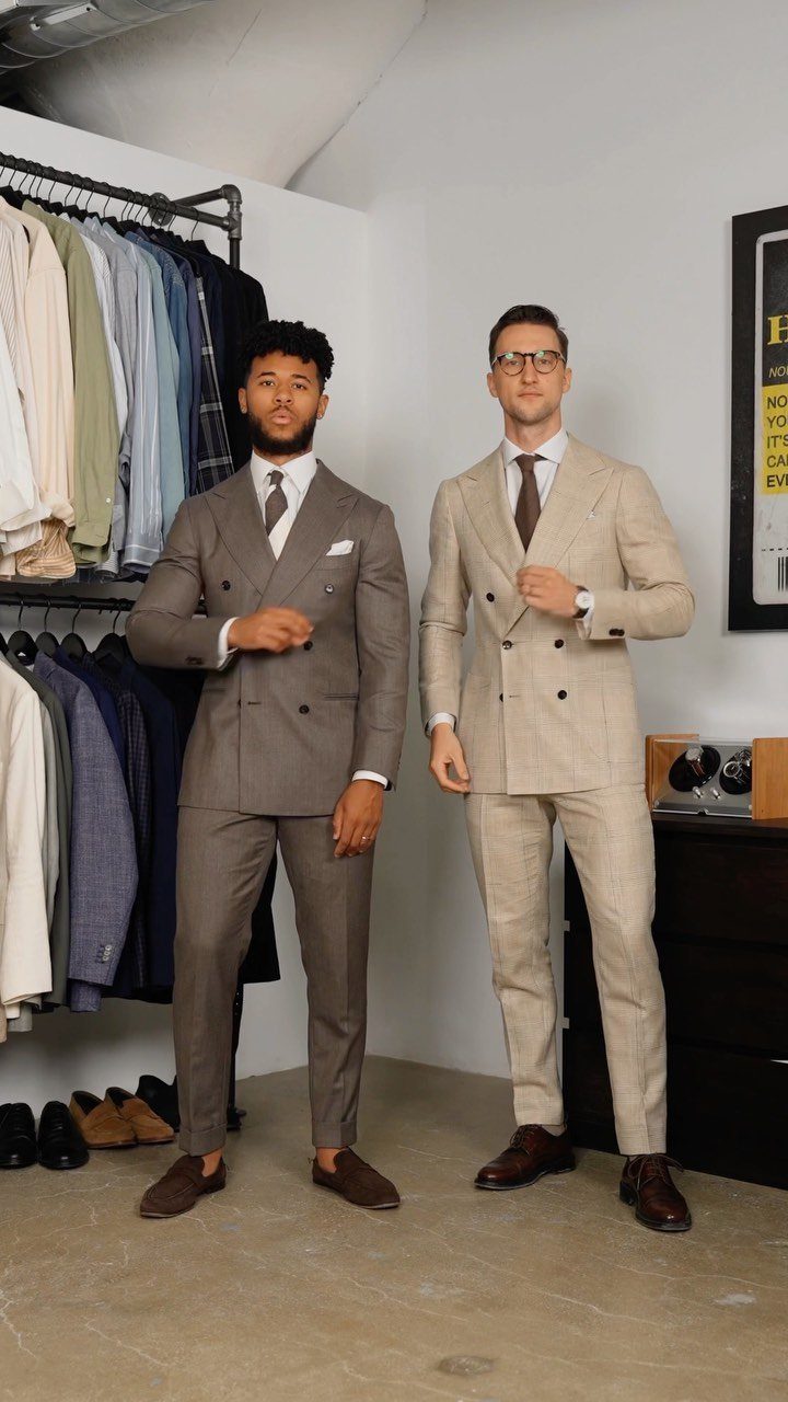 Two men posing in stylish double-breasted suits standing in a clothing boutique.